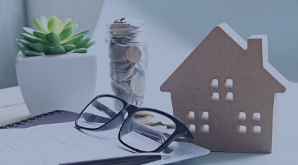Housing Programs - Image of Toy House with Notebook and glasses
